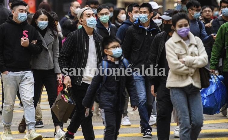 Un grupo de personas en Hong Kong camina con barbijo para evitar contagiarse. (Foto: AFP)